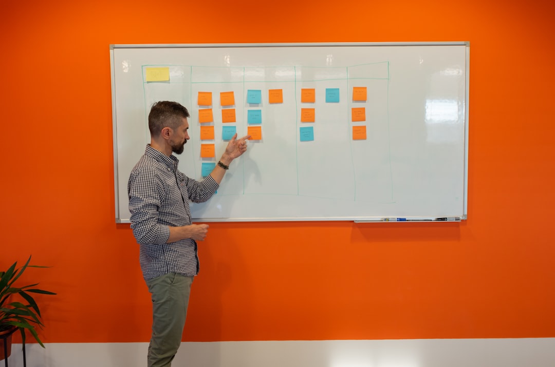 Business team mapping a marketing funnel on a whiteboard with sticky notes