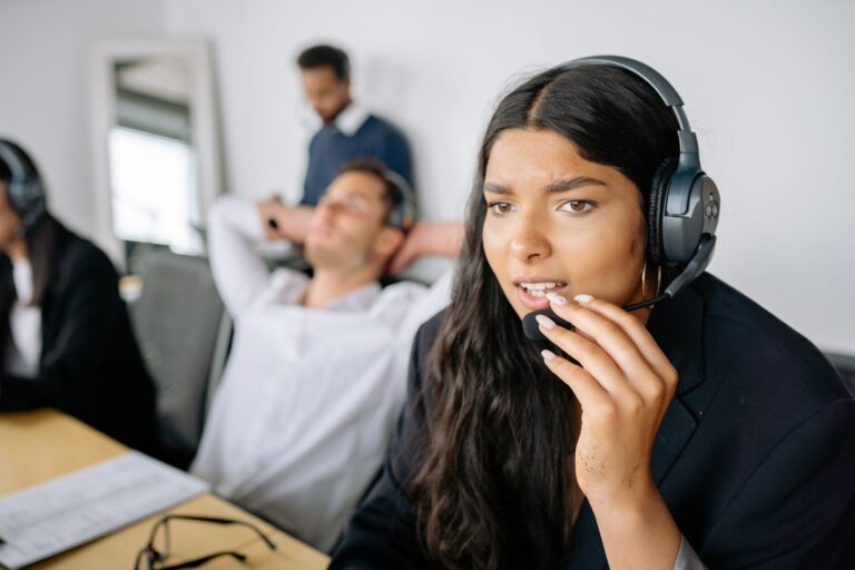 Call center agents wearing headsets making outbound sales calls in an office
