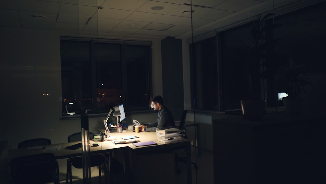On-call admissions coordinator answering a late-night intake call at a desk