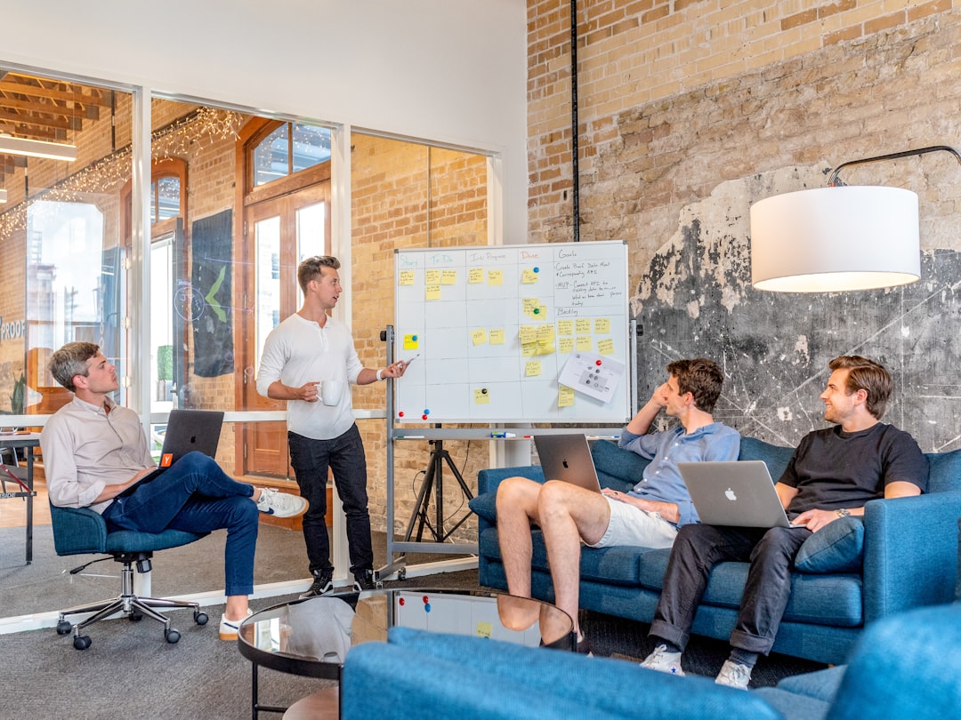 A sales team reviewing lead performance metrics and conversion data on a whiteboard during an office meeting.
