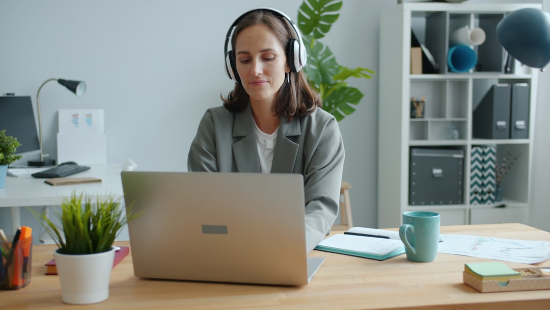 Call center supervisor reviewing compensation data on a laptop at their desk.