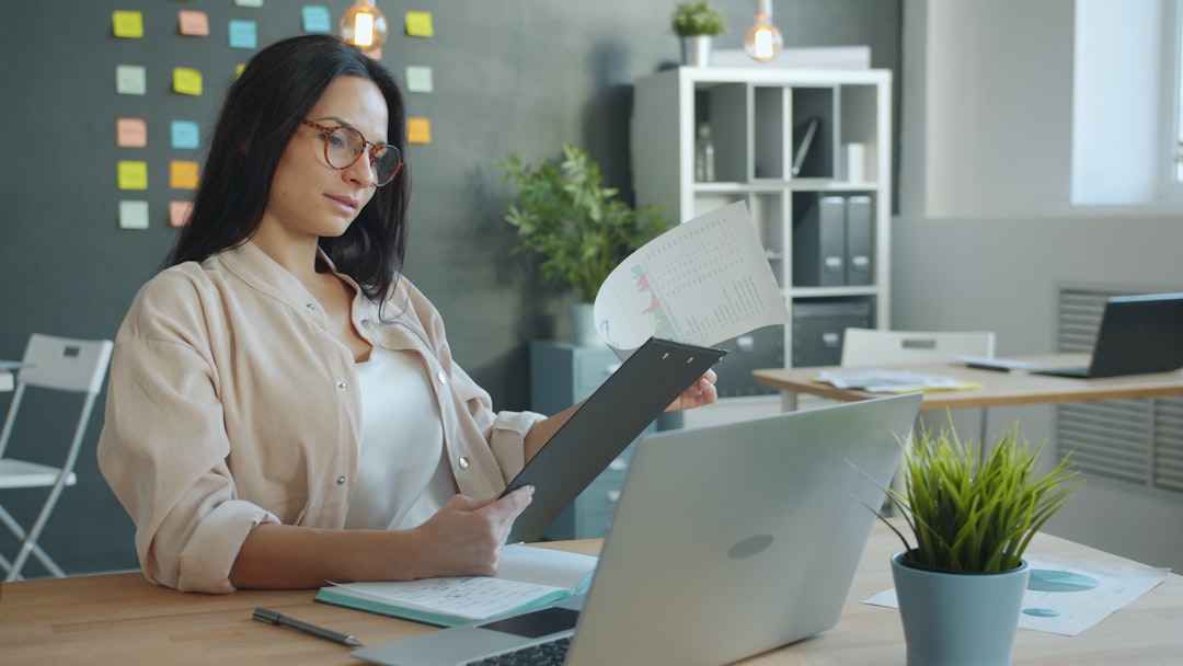 Healthcare professional reviewing compliance documents and legal paperwork at a desk.